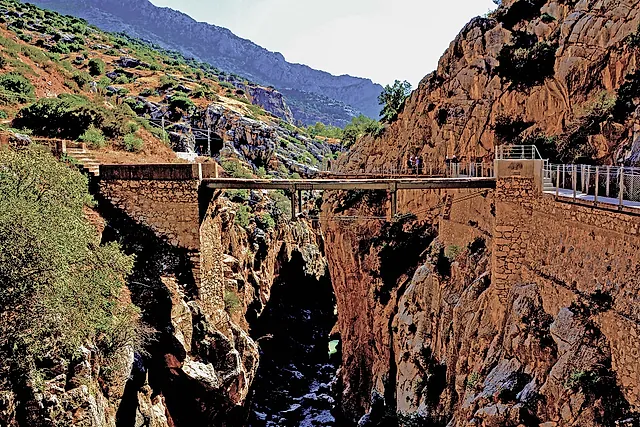 Un ponte sospeso sopra la gola tra rupi rossastre lungo il Caminito del Rey